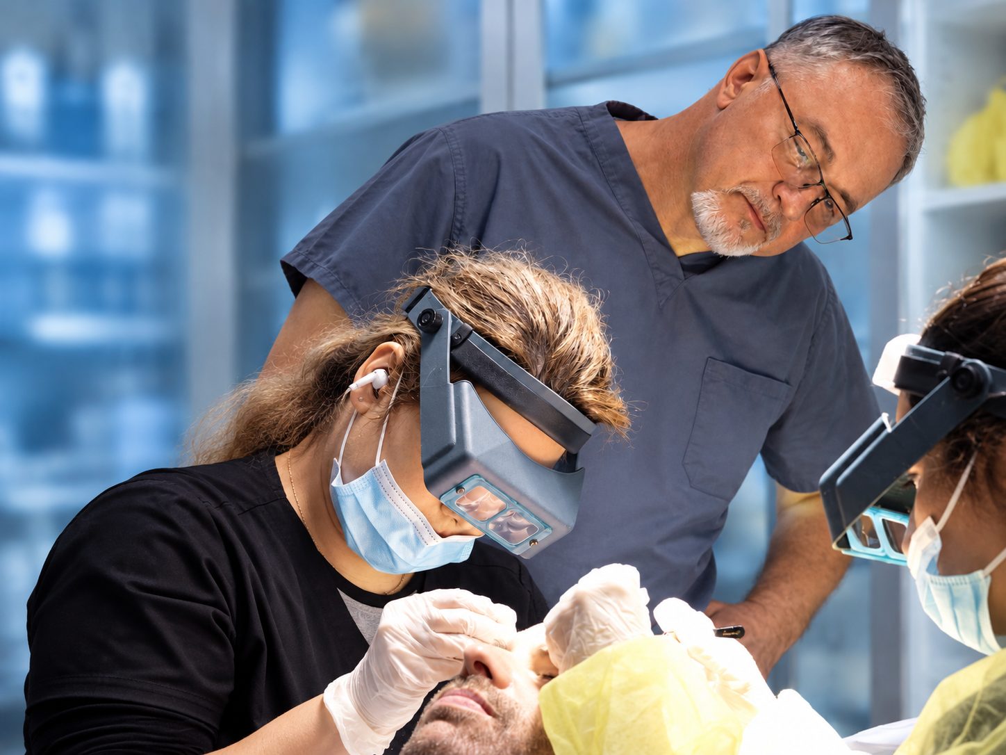 Technician working under magnifying loupes while Dr. Val Prokurat, MD oversees a transplant procedure at Nova Medical Long Island